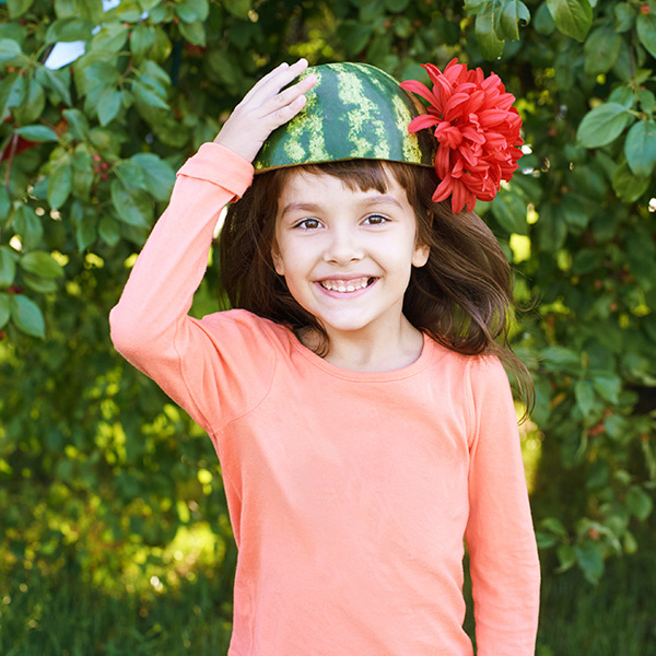niña con media sandia en la cabeza